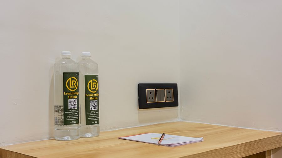 Lemonridge Hotels, KPHB | Hotel room with a desk, chair, and a bottle of water. Work-friendly space.